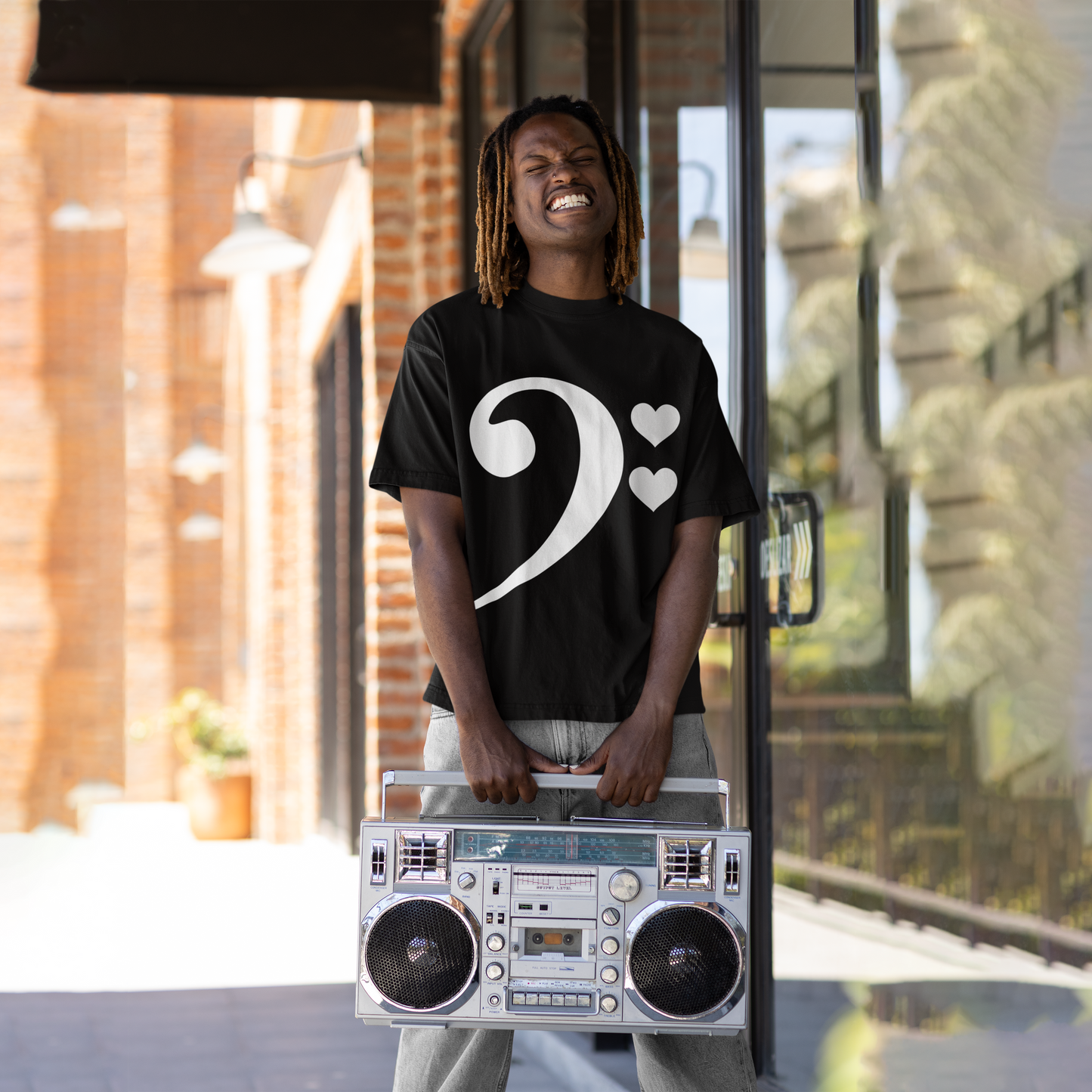 A man holding a boombox and wearing For The Love of Bass Unisex Tee, black