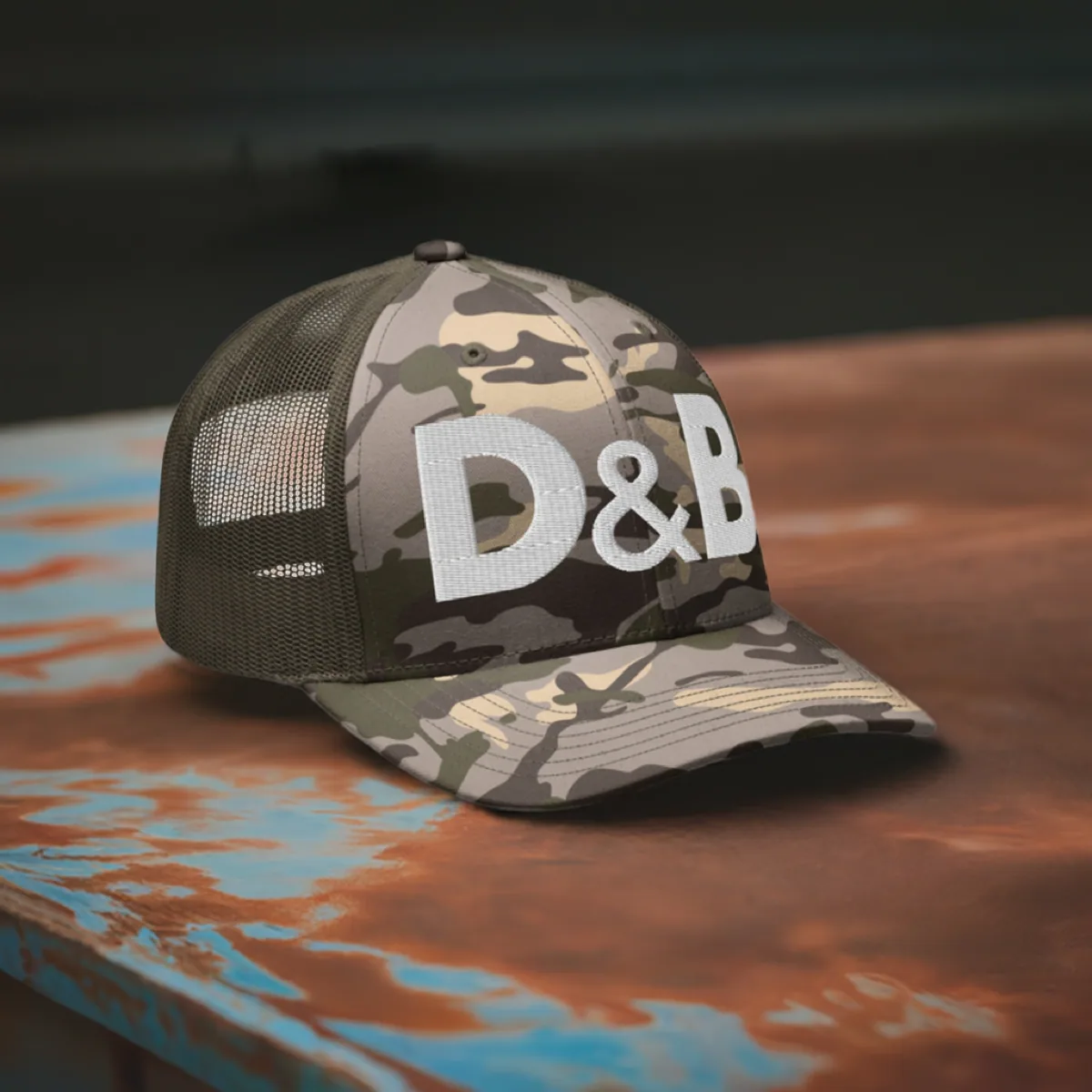 D&B Camouflage Trucker Cap sitting on a table